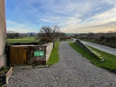 a gravel road with a sign on the side of a building at 3 Bed in Aspatria 89139 in Aspatria