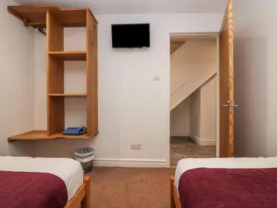 a bedroom with two beds and a tv on the wall at 8 Little Mell Fell in Penrith