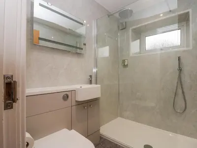 a bathroom with a shower and a toilet and a sink at 8 Little Mell Fell in Penrith