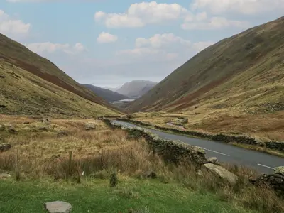 a river in the middle of a valley with mountains at 8 Little Mell Fell in Penrith