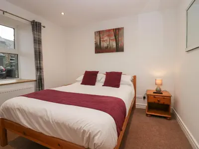 a bedroom with a large bed and a window at 8 Little Mell Fell in Penrith