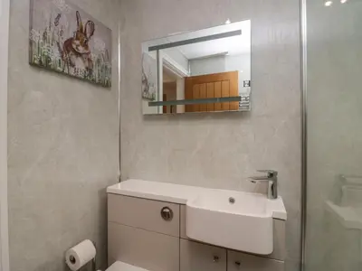 a bathroom with a white sink and a mirror at 8 Little Mell Fell in Penrith