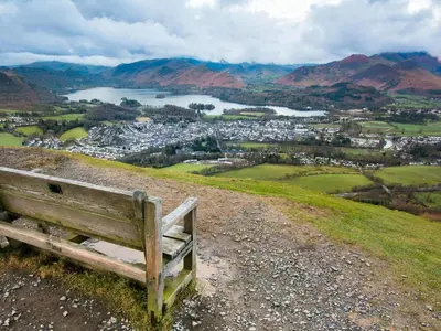 a bench sitting on top of a hill overlooking a city at 3 Bed in Keswick oc-90266 in Applethwaite