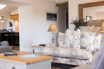 a living room with a couch and a table at Sheepfold Barn in Penruddock