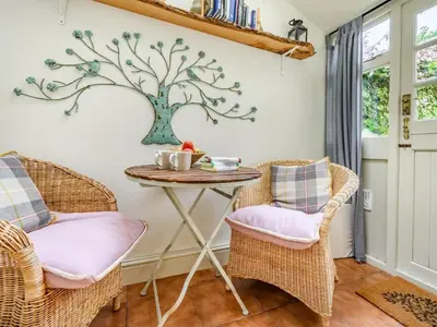 a room with two chairs and a table with a tree on the wall at 2 Bed in Keswick oc-sz427 in Keswick