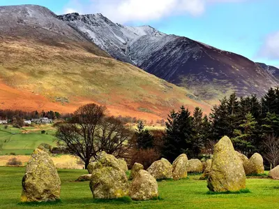 a field with rocks in front of a mountain at 1 Bed in Ullswater 90300 in Penruddock