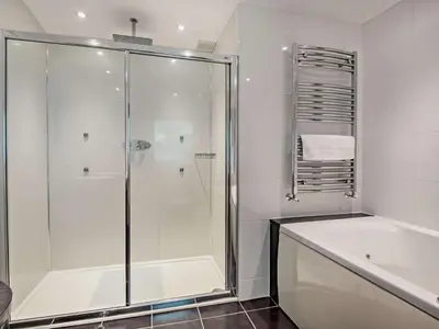 a bathroom with a shower and a tub and a sink at 6 Bed in Keswick oc-90333 in Keswick