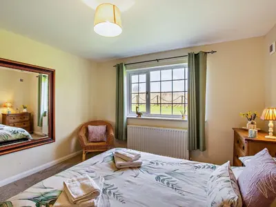 a bedroom with a bed and a mirror and a chair at 3 Bed in Dovenby 90920 in Tallentire