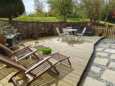 a wooden deck with chairs and a table and a table and chairs at 2 Bed in Dearham 91132 in Dearham