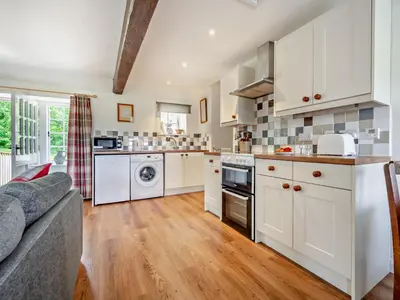 a kitchen with white cabinets and a couch at 1 Bed in Mosedale 91232 in Mosedale