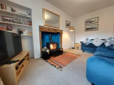 a living room with a blue couch and a fireplace at 2 Bed in Glenridding 90874 in Glenridding