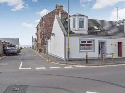 a white building on the side of a street at Corner Cottage in Girvan