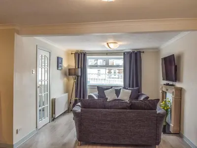 a living room with a couch and a window at Corner Cottage in Girvan