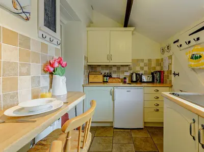 a kitchen with a counter with a vase of flowers at 1 Bed in Gilcrux 92218 in Gilcrux