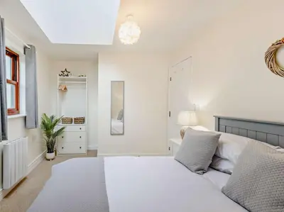 a white bedroom with a bed and a lamp at 2 Bed in Keswick 91901 in Keswick