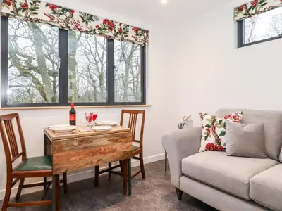a living room with a table and a couch at Herdwick Cabin in Penrith