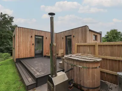 a small wooden house with a wooden deck at Herdwick Cabin in Penrith