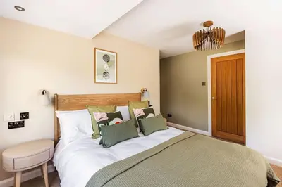 a bedroom with a large bed and a chair at Langdale Boulders, Ambleside, Fantastic views in Chapel Stile