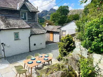a patio with a table and chairs in front of a house at Langdale Boulders, Ambleside, Fantastic views in Chapel Stile