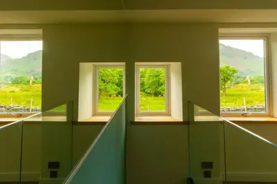 three windows in a room with a view of a field at Langdale Boulders, Ambleside, Fantastic views in Chapel Stile
