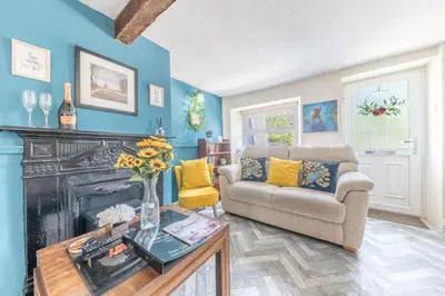 a living room with a couch and a fireplace at Charming Cottage, Lake District in Little Broughton
