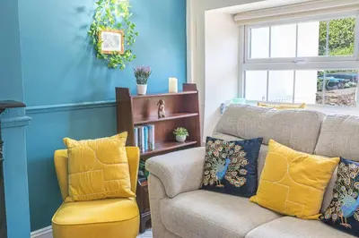 a living room with a couch and a chair at Charming Cottage, Lake District in Little Broughton