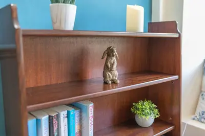 a statue of a dog sitting on a book shelf at Charming Cottage, Lake District in Little Broughton