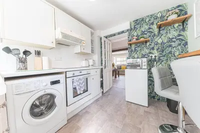 a kitchen with a washing machine and a dishwasher at Charming Cottage, Lake District in Little Broughton