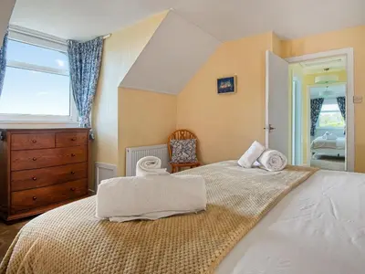 a bedroom with a large bed with towels on it at High Auchenlarie Cottage in Carsluith
