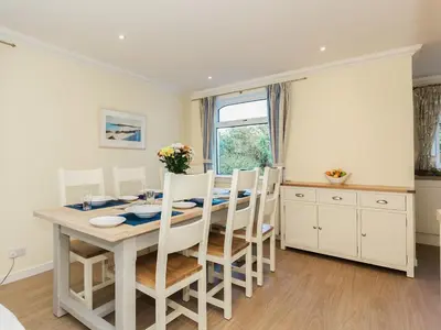 a kitchen and dining room with a table and chairs at High Auchenlarie Cottage in Carsluith