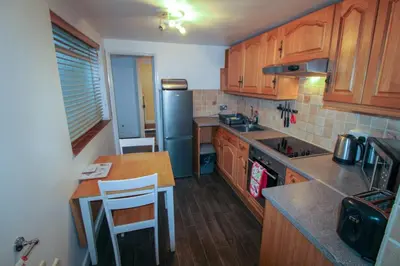 a kitchen with wooden cabinets and a blue refrigerator at Carlton Cottage all ground floor, centrally located in Keswick in Keswick