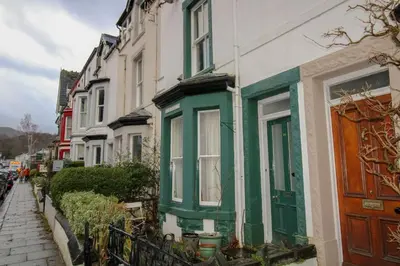 a row of houses with green trim on a street at Carlton Cottage all ground floor, centrally located in Keswick in Keswick