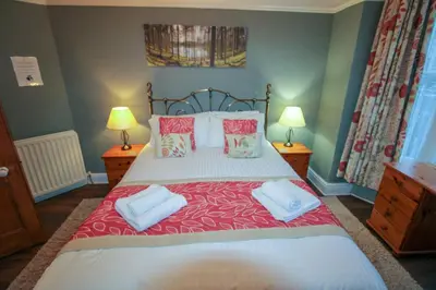 a bedroom with a large bed with two lamps at Carlton Cottage all ground floor, centrally located in Keswick in Keswick