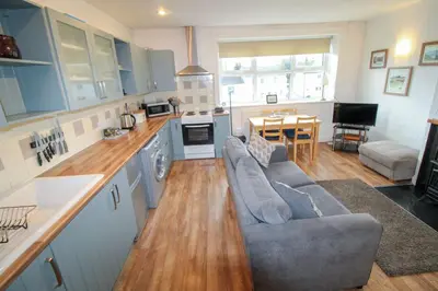 a living room with a couch and a kitchen at Emilys Nook Ireby, budget accommodation with fell views in Ireby