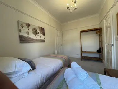 two beds in a room with a mirror at Ellergill in Keswick