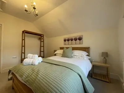 a bedroom with a large bed and a mirror at Ellergill in Keswick