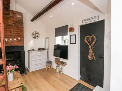 a living room with a black door with a heart on the wall at High Wreah Bolt Hole in Whitehaven