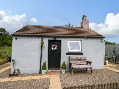a small house with a bench in front of it at High Wreah Bolt Hole in Whitehaven