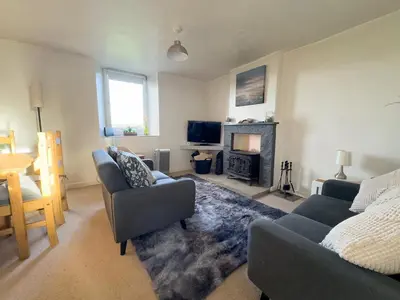 a living room with two couches and a fireplace at Escape to our Cosy Cottage with Log Burner in Drigg, Lake District in Drigg