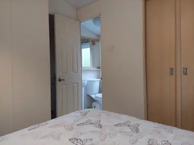 a bedroom with a bed and a bathroom at Winnie - Caravan mit Meerblick in Drummore