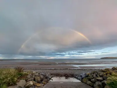 twobows in the sky over a beach with the ocean at Winnie - Caravan mit Meerblick in Drummore