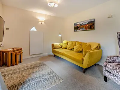 a living room with a yellow couch and a table at 2 Bed in Keswick oc-28383 in Braithwaite