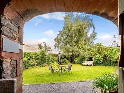 an archway with a table and chairs in a yard at 1 Bed in Keswick oc-28382 in Braithwaite