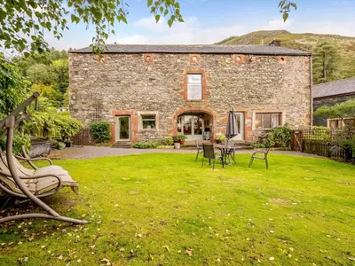 an exterior view of a stone house with a yard at 1 Bed in Keswick oc-28382 in Braithwaite