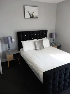 a bedroom with a large white bed with two lamps at Fleet Townhouse in Gatehouse of Fleet