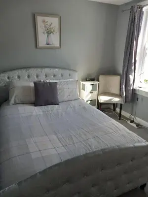 a bedroom with a large bed and a chair at Fleet Townhouse in Gatehouse of Fleet
