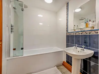 a white bathroom with a sink and a tub and a shower at 2 Bed in Bassenthwaite 93463 in Ireby