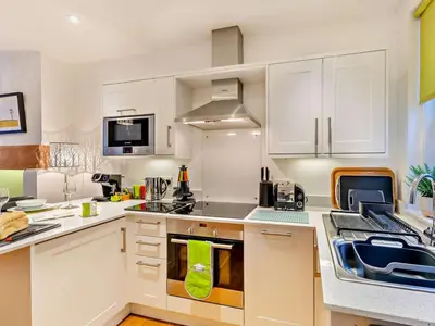 a kitchen with white cabinets and a stove top oven at 1 Bed in Keswick 93386 in Keswick