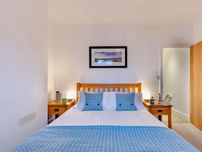 a bedroom with a blue bed with blue pillows at 1 Bed in Keswick 93386 in Keswick