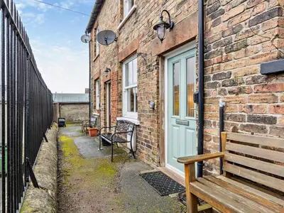 a brick building with a bench next to a door at 1 Bed in Keswick 93386 in Keswick